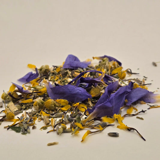 Dried blue lotus petals, chamomile, and california poppy by Astral Herbal on a white background.