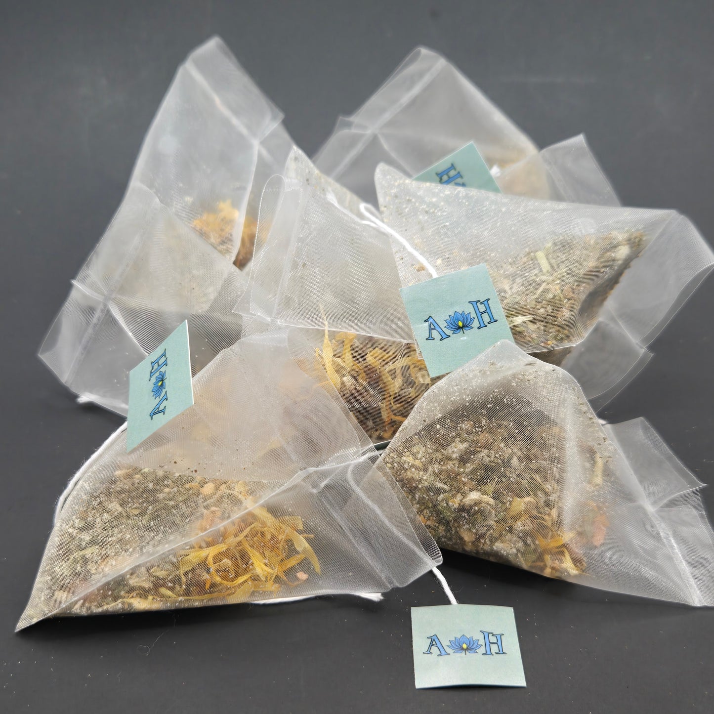 Astral Herbal mindful uplift tea bags with calendula rhodiola root tulsi holy basil peppermint on a black background.