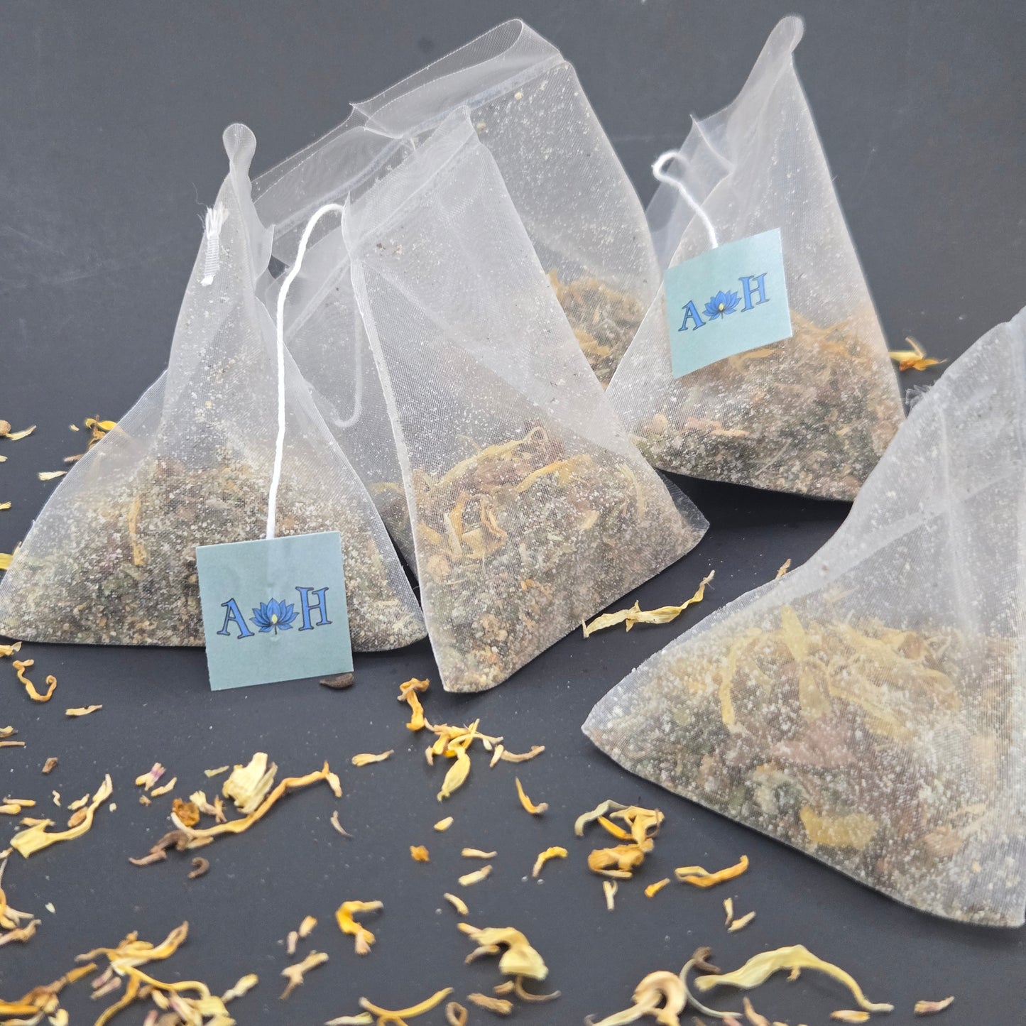 Astral Herbal mindful uplift tea bags with calendula rhodiola root tulsi holy basil peppermint on a black background.