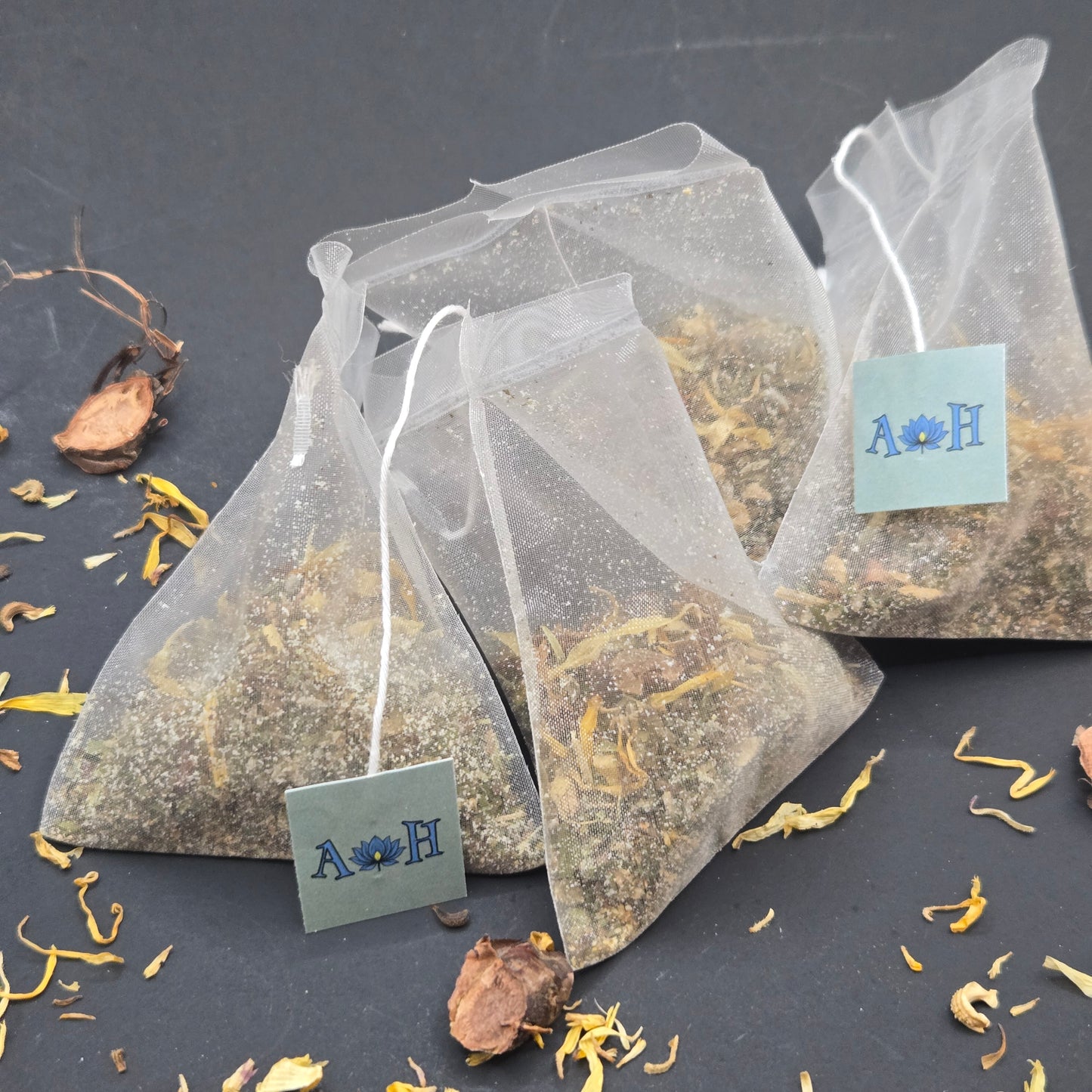 Astral Herbal mindful uplift tea bags with calendula rhodiola root tulsi holy basil peppermint on a black background.