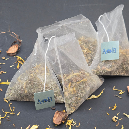 Astral Herbal mindful uplift tea bags with calendula rhodiola root tulsi holy basil peppermint on a black background.