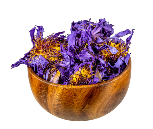 Wooden bowl filled with blue lotus dried flowers on a white background