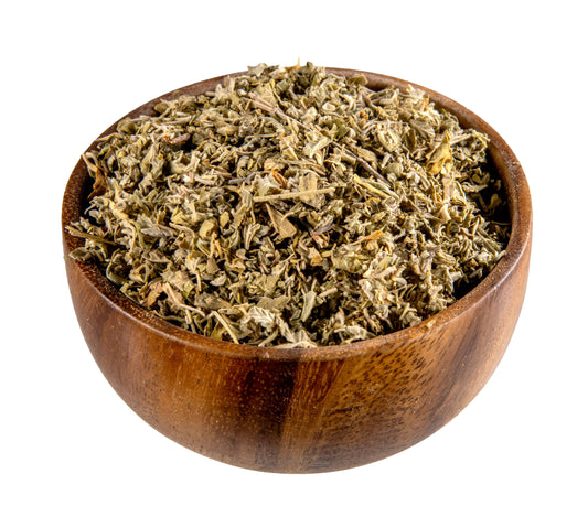 Wooden bowl filled with dried herbs on a white background