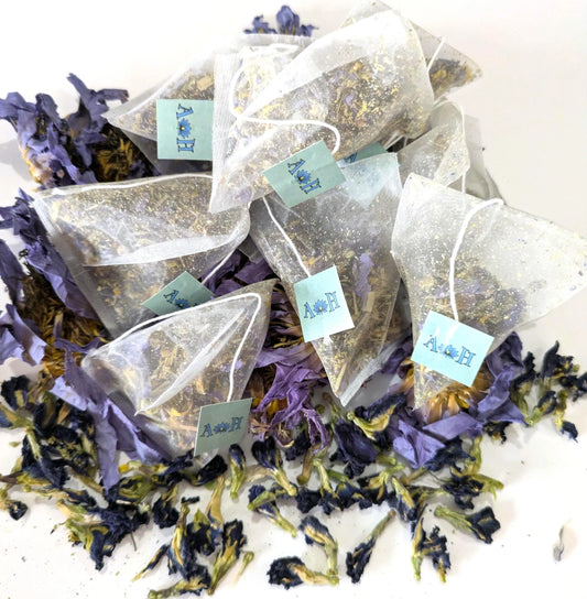 Tea bags with butterfly pea flowers, blue lotus, chamomile, and lemongrass on a white background by Astral Herbal