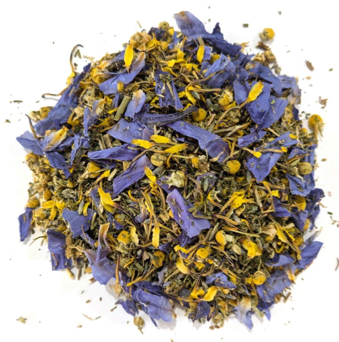 Dried blue lotus petals, chamomile, and california poppy by Astral Herbal on a white background.