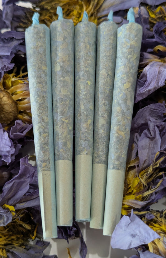blue lotus pre rolls stacked on top of whole blue lotus flowers by Astral Herbal