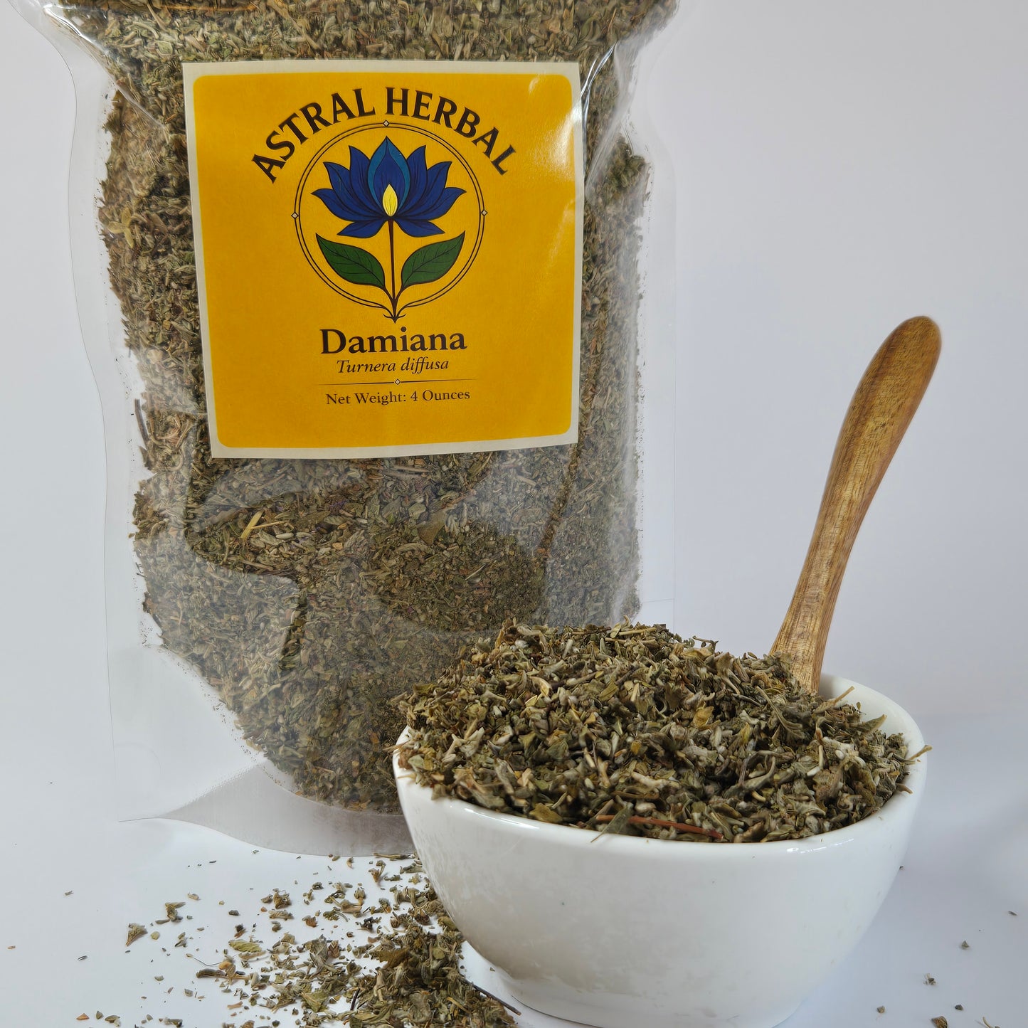 Dried herbs in a white container with a wooden scoop, next to an Astral Herbal Damaiana package on a white background.