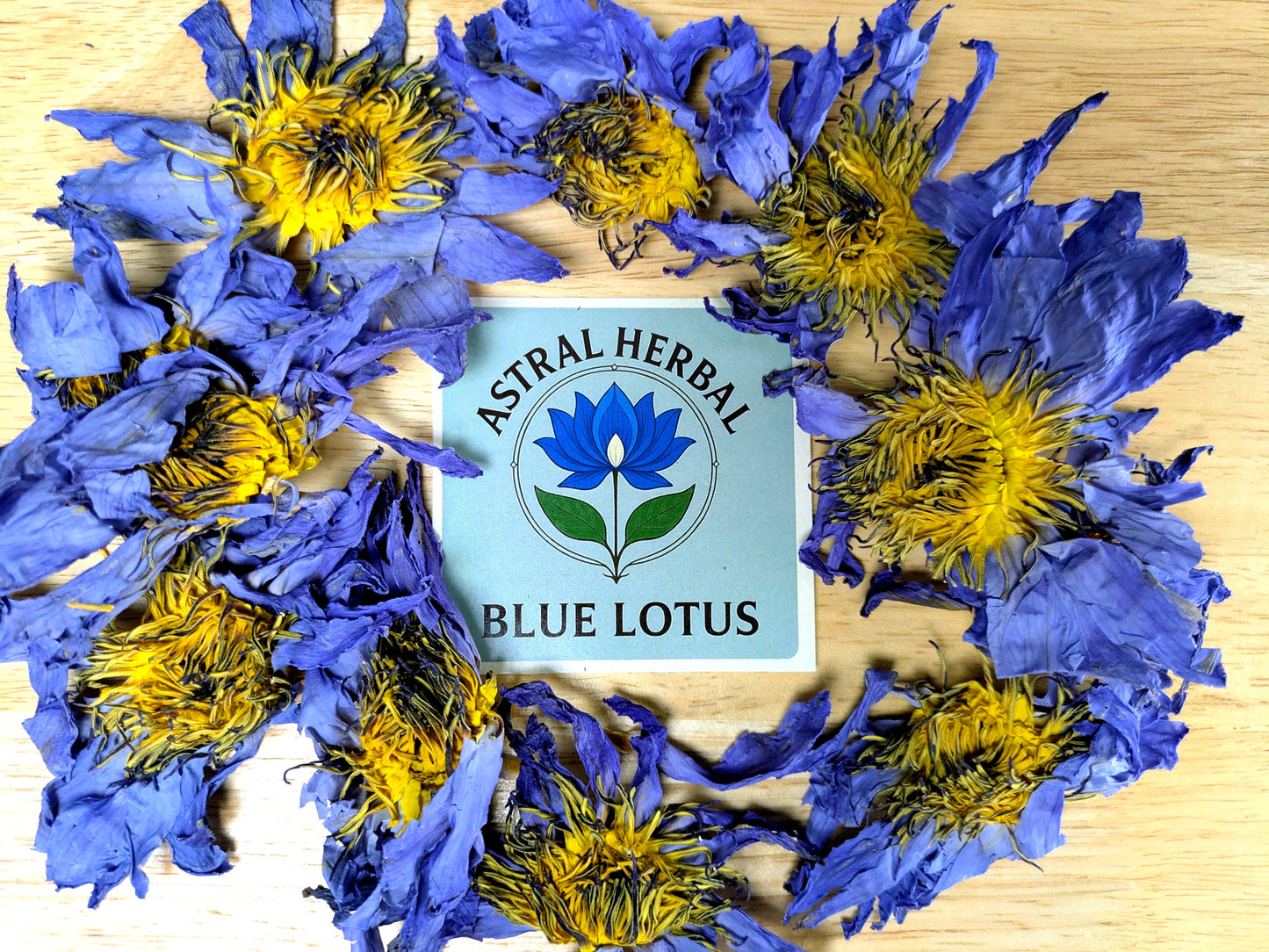 Blue and yellow lotus flowers with Astral Herbal Blue Lotus logo on a wooden background