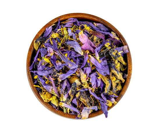 Wooden bowl filled with purple and yellow dried flowers on a white background