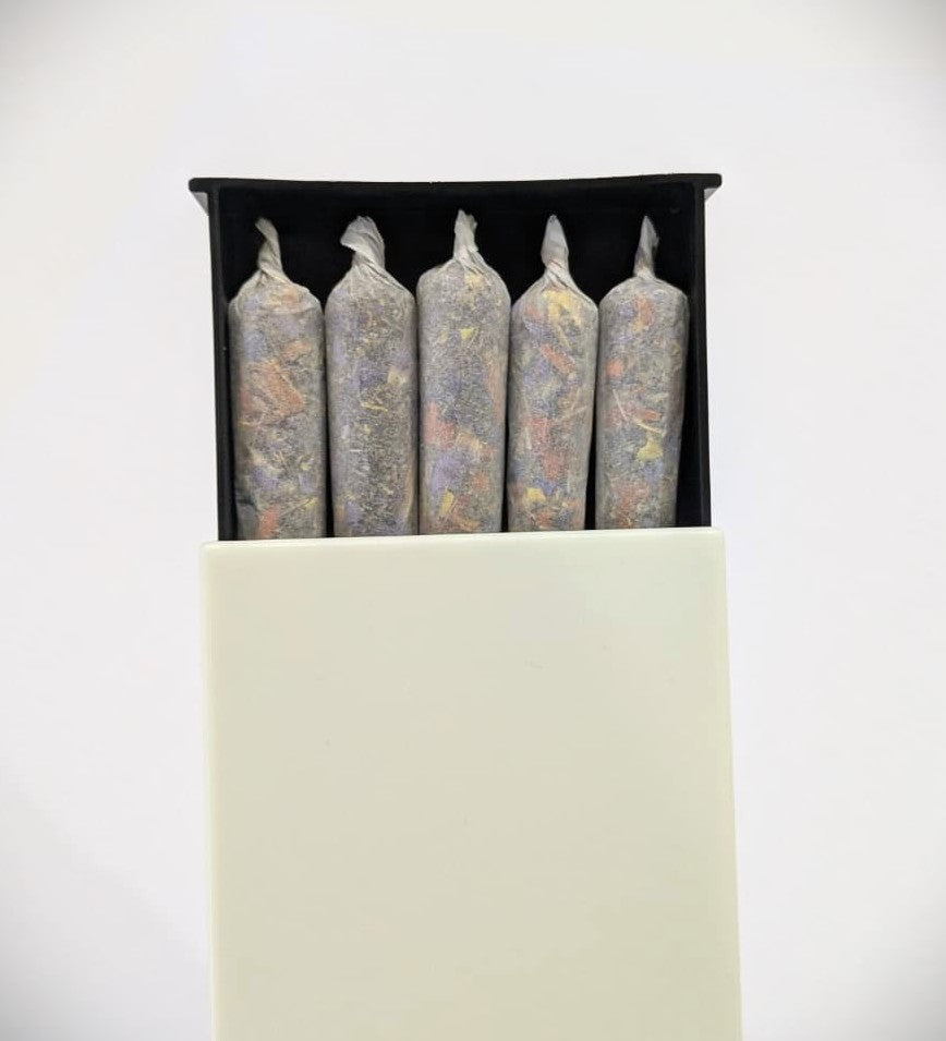 Five herbal cigarette pre rolls in a plastic slide box on a white background by Astral Herbal.
