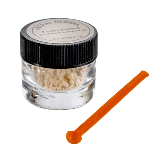Small glass jar with kanna extract powder and an orange stir stick on a white background