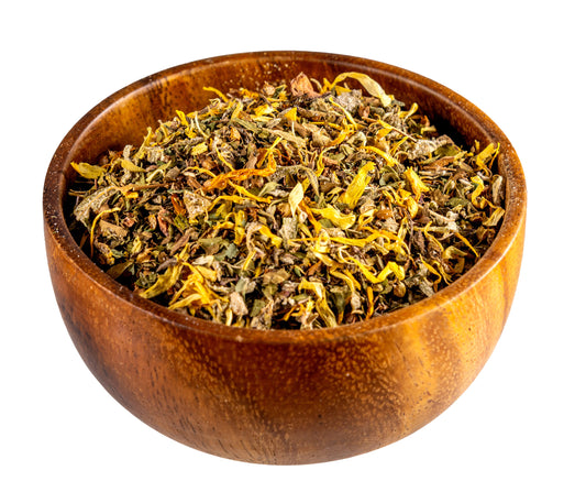 Wooden bowl filled with dried herbs on a white background