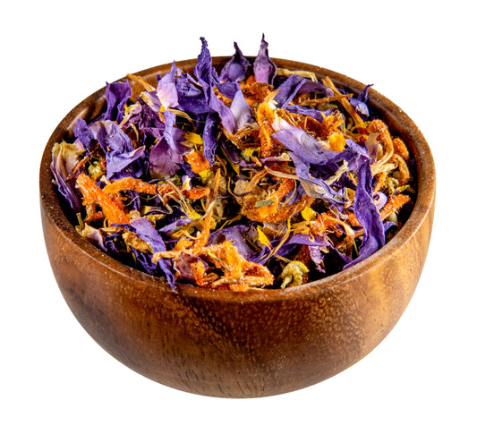 Wooden bowl filled with dried purple and orange flowers on a white background