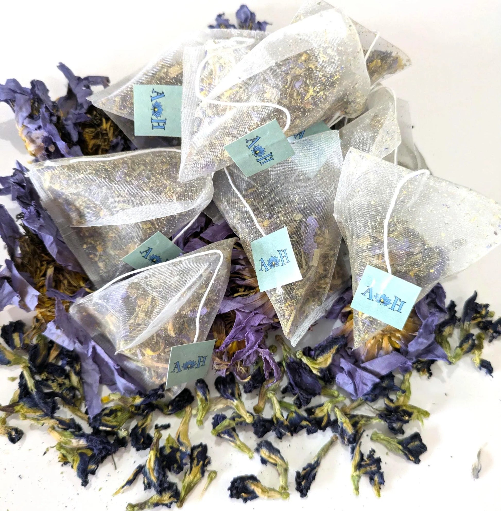 Tea bags with butterfly pea flowers, blue lotus, chamomile, and lemongrass on a white background by Astral Herbal