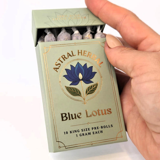 Astral Herbal Blue Lotus pre-rolls packaging held by a hand on a white background