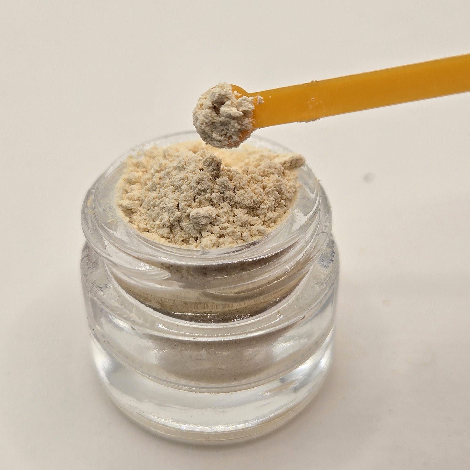 Kanna extract MT-55 in a glass jar with a microdose spoon by Astral Herbal.