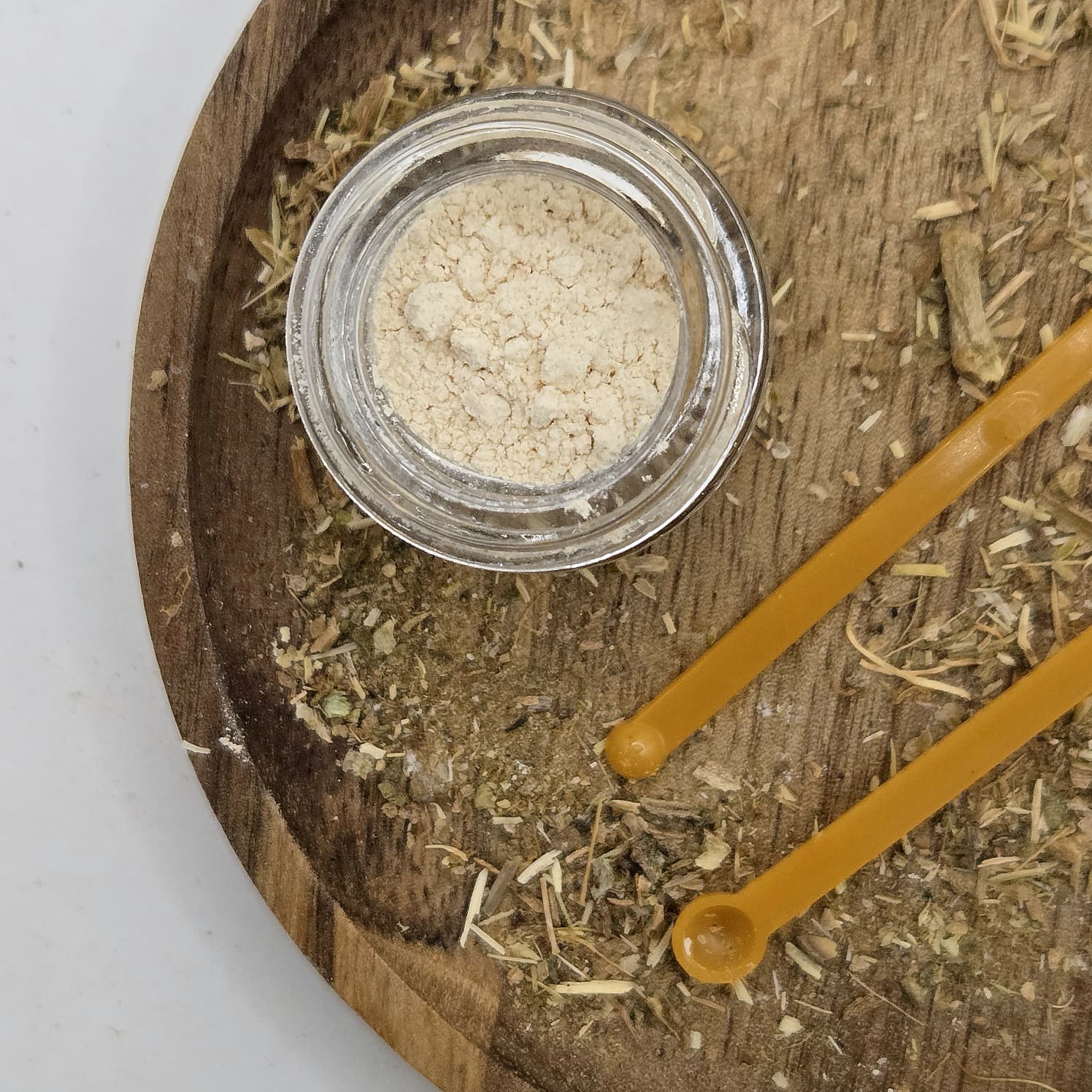 Kanna extract MT-55 in a glass jar with a background of fermented kanna by Astral Herbal.